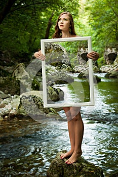 Lady nature - beoutiful young wman stands in nature with a frame