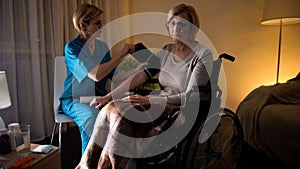 Lady nurse measuring woman blood pressure, hypertension, old age hopelessness