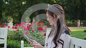 Lady in the Park Using a Tablet