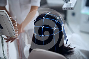 Lady patient in a silicone cap undergoing the EEG procedure