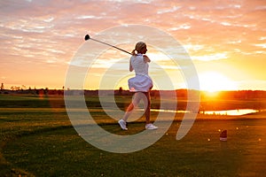 Lady Play Golf With Sunset Background .