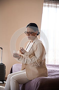 Lady preparing to take medication upon arrival at hotel room