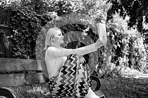 Lady pretty bookworm busy read book outdoors sunny day. Literary critic. Woman concentrated reading book in garden