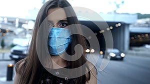 Lady in protective mask in big city, air pollution, epidemic or airborne disease