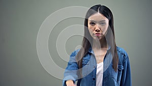 Lady pulling hand forward, showing stop sign, racial and gender discrimination