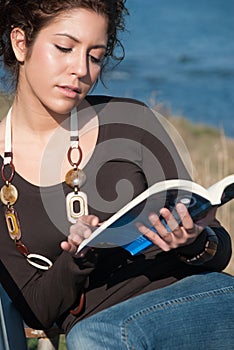 Lady reading a book at the seaside