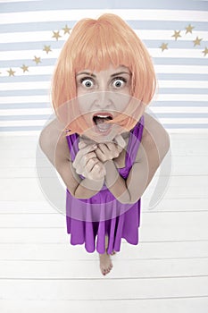 Lady red or ginger wig posing in blue dress. Comic actress concept. Woman playful mood having fun. Fun and entertainment