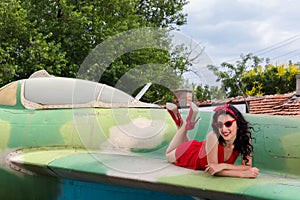 Lady in red on vintage aircraft wing