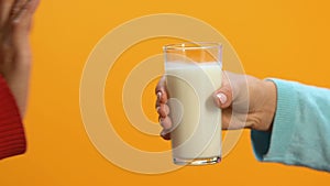 Lady refusing glass of milk offered by person, allergy and lactose intolerance