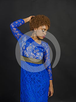 Lady on relaxed face with makeup and afro hairstyle. Lady in dress made out of lace. Woman with african appearance in