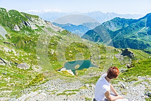 Lady resting on the mountain summit, expansive panorama