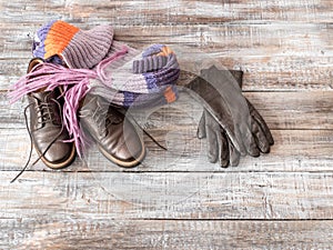 Lady`s footwear and cloves on wooden background.