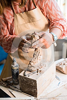 Lady sculptor working in her studio, ceramis artist`s hands