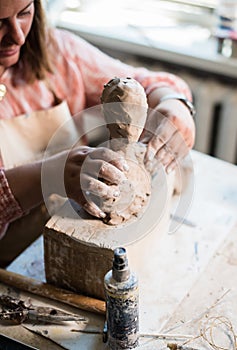 Lady sculptor working in her studio, ceramis artist`s hands