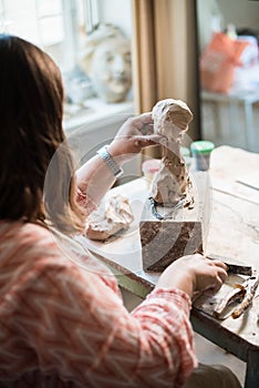 Lady sculptor working in her studio, ceramis artist`s hands