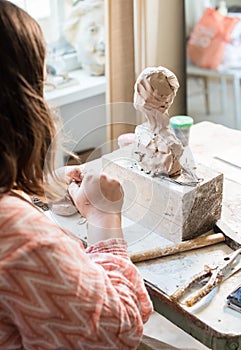 Lady sculptor working in her studio, ceramis artist`s hands