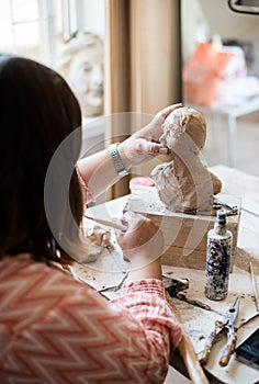 Lady sculptor working in her studio, ceramis artist`s hands