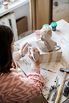 Lady sculptor working in her studio, ceramis artist`s hands