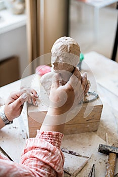 Lady sculptor working in her studio, ceramis artist`s hands