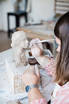 Lady sculptor working in her studio, ceramis artist`s hands