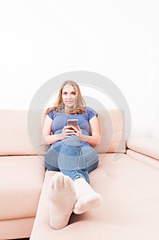 Lady sitting on couch holding smartphone