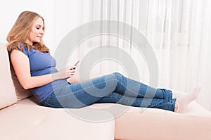 Lady sitting on couch texting on smartphone