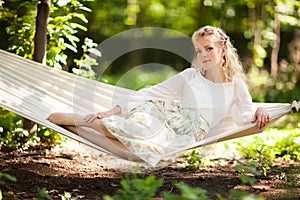 Lady sitting on tree hammock swing bed.