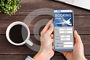 Lady With Smartphone Booking Flight Tickets Sitting At Desk Indoors