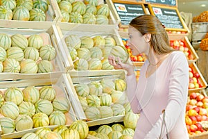 Lady smelling melon in grocers photo
