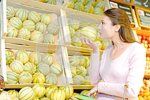 Lady smelling melon for ripeness