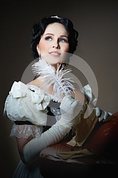 A lady with a smile in a historical costume with a feather in her hand and a letter. Design for the cover of the book.