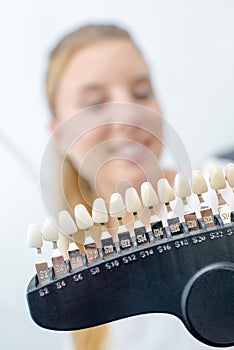 Lady smiling behind row false teeth