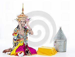 The lady in Southern thai classical dancing suit is posing on white background.she is putting the headdress on her head,