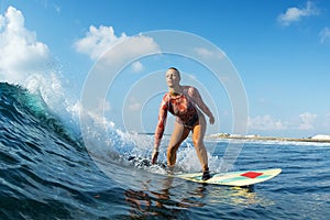 Lady surfer rides perfect ocean wave