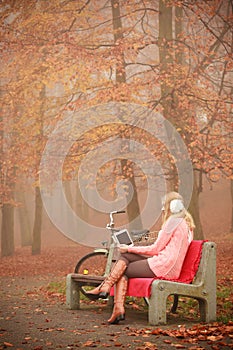 Lady with tablet in park.