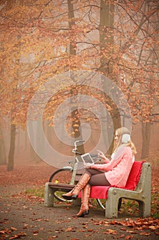 Lady with tablet in park.