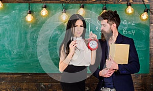 Lady teacher and strict schoolmaster care about discipline and rules in school. Man with beard hold book and girl