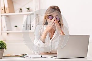 Lady Touching Nosebridge Having Sinusitis Sitting At Laptop At Workplace