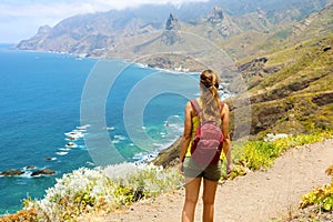 Lady tourist with a backpack standing on mountain enjoy the beautiful landscape of Tenerife Island