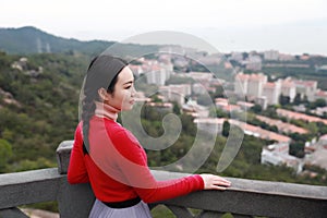 Lady tourist standing on a rock on the top of mountain and admire the view , Xiamen, China