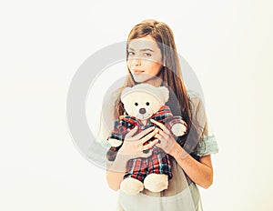 Lady in transparent blue nightie holds teddy bear in hands, white background, copy space. Girl with plush bear toy