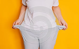 Lady turned out her empty pockets against a yellow background