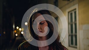 Lady walking dark street enjoying night town close up. Woman strolling city