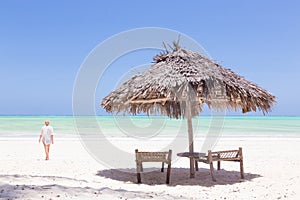 Lady walking to the sea oat white sandy tropical beach of Paje, Zanzibar, Tanzania.