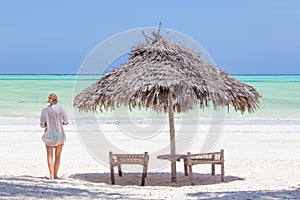 Lady walking to the sea oat white sandy tropical beach of Paje, Zanzibar, Tanzania.