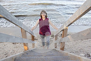 Lady walking up stairs by the beach