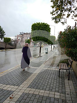 A lady walks in the rain for shopping