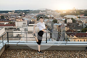 Lady warming-up legs before training on gravel roof