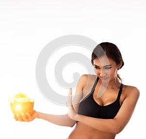 The lady is wearing black sport bra,hold potato chips bowl in hand and push it out from body,reject unhealthy food,wiht unhappy fa