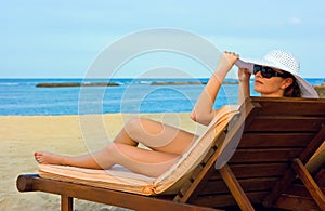 Lady with white hat on the beach